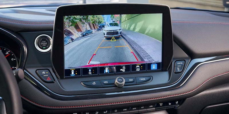 Dashboard screen showing a rearview camera display of a Chevrolet SUV.