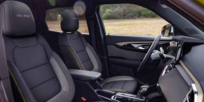 Close-up of black leather seats with yellow stitching.