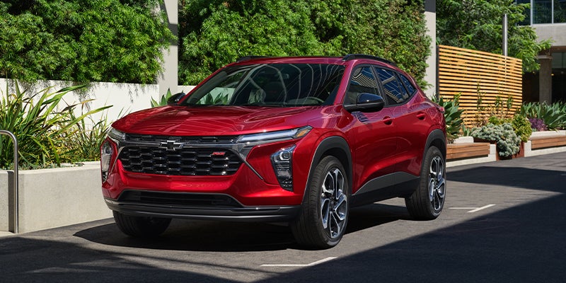 Red Chevrolet Trax compact SUV parked on a sunny city street